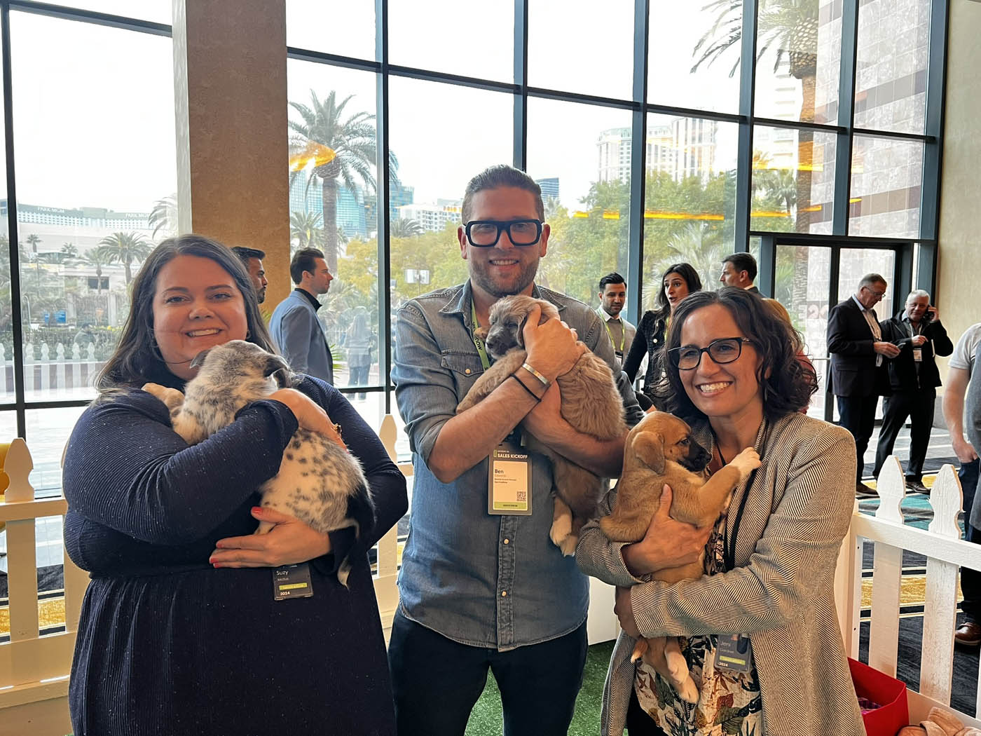 A group of people holding adorable puppies and feeling the benefits of Puppy Love added to their Silicon Valley / Bay Area company wellness programs.