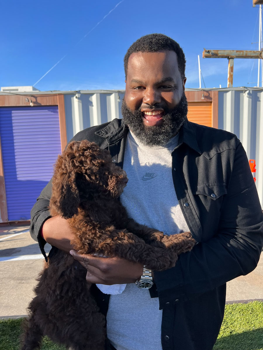 A happy man holding an adorable puppy - thanks to Puppy Love and our workplace events in Las Vegas, NV.