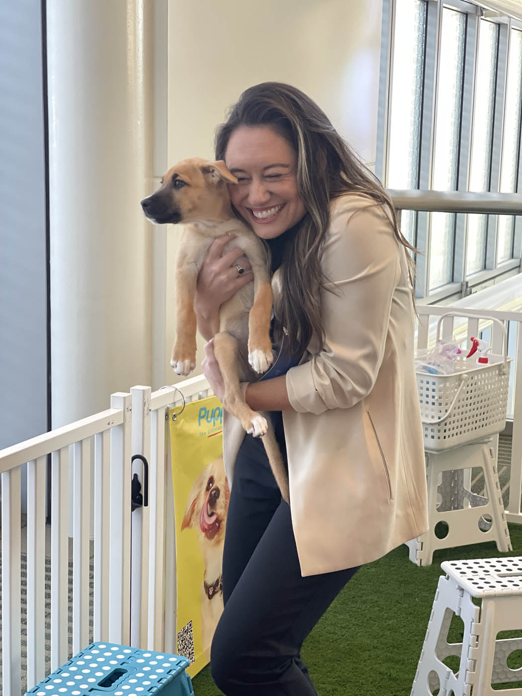 A woman holding a puppy and experiencing so much joy thanks to Puppy Love.