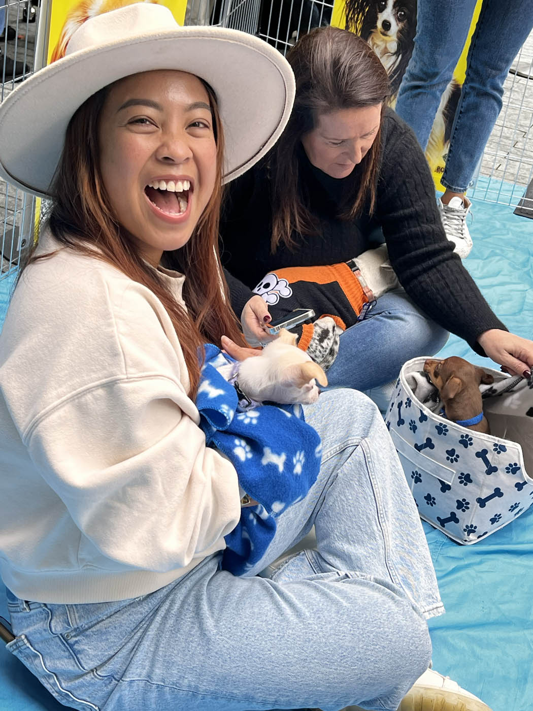 A girl in white clothing holding an adorable Puppy Love furry companion - Silicon Valley / Bay Area company wellness programs.