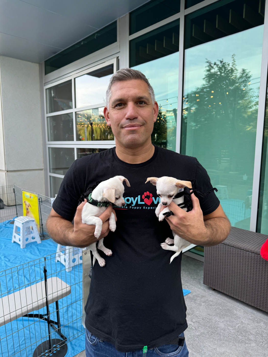 Man in Puppy Love shirt holding two adorable puppies in customes at google's halloween celebration event!
