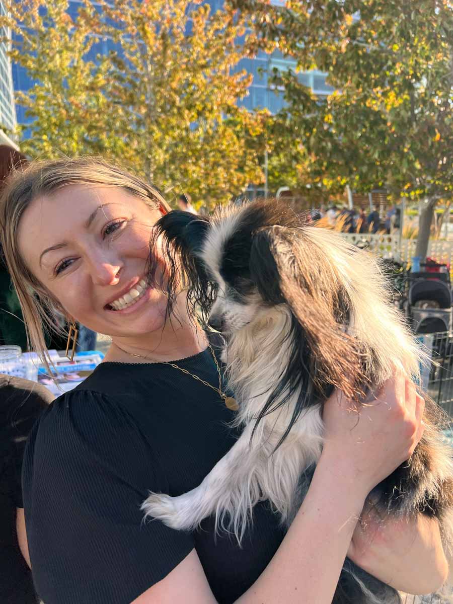 Woman at a google event holding a puppy from Puppy Love's puppy experience.