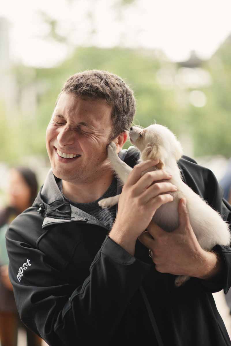 An employee enjoying Puppy Love™ Northern California's puppy experience as part of incorporating work wellness program ideas in Silicon Valley / Bay Area.