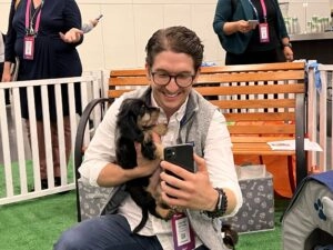 Pure Joy At A Gainsight Pulse 2022 4 A man and a black puppy.