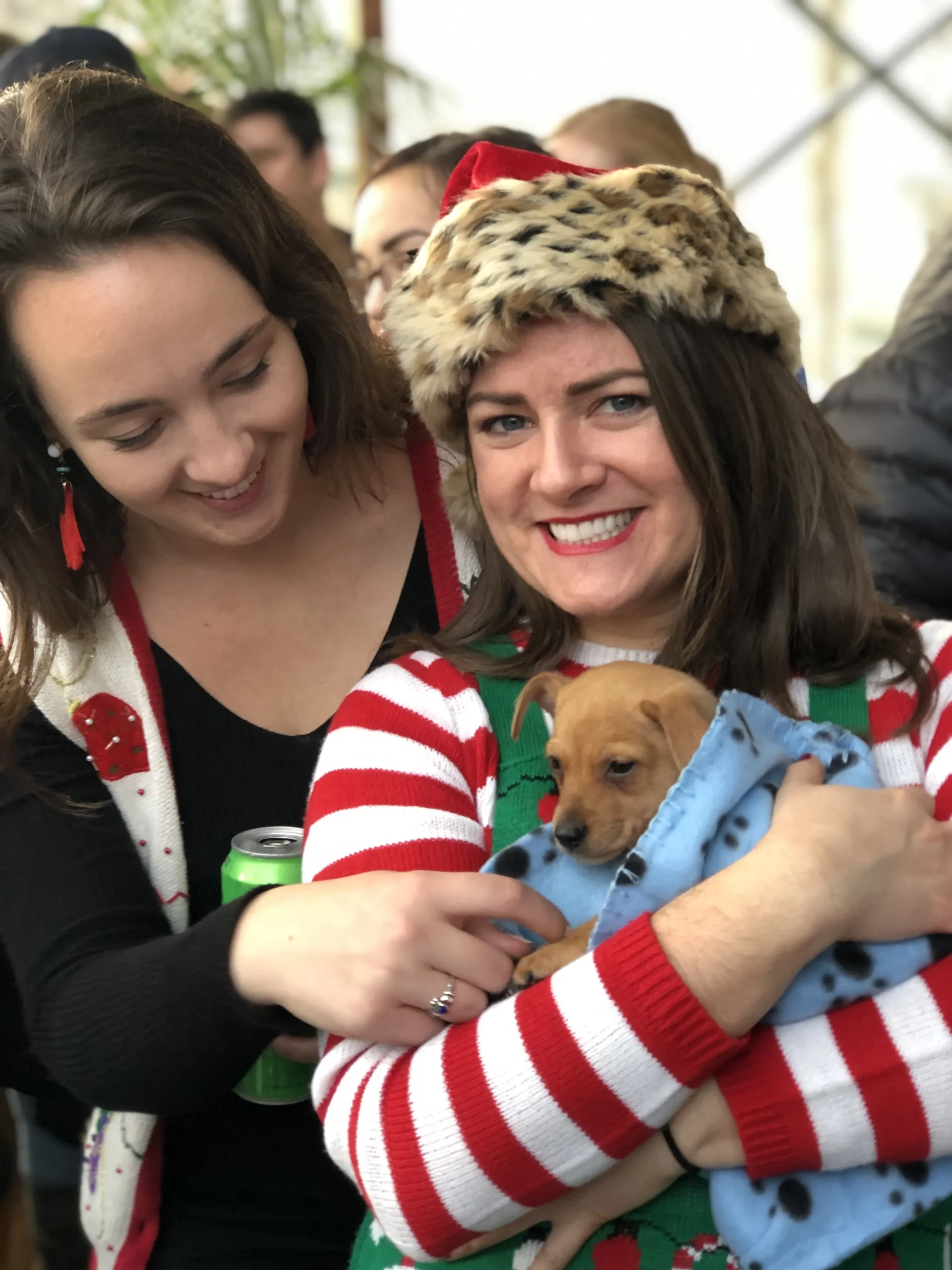 alt="Two girls with puppies at a corporate holiday event with Puppy Love!
