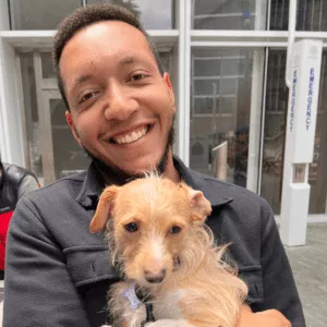 Why Dogs Make Us Smile 3 A man holding a puppy.