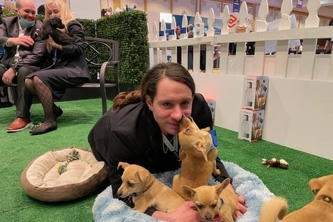 Puppies At A Trade Show? Genius!! 4 Business person playing with small pups.