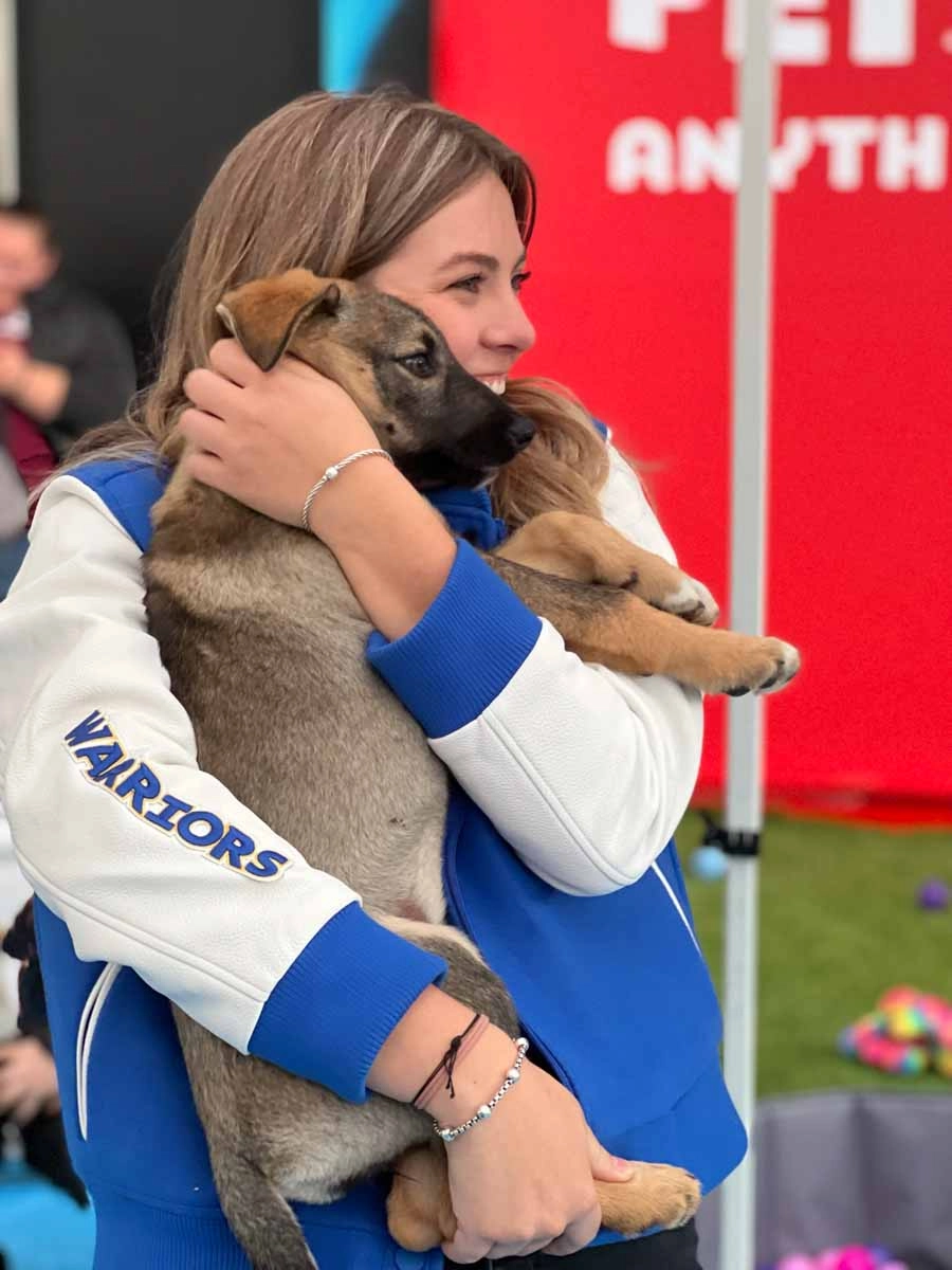 Sporting-066 Smile as big as this person when you hold a puppy at a community sports and wellness center event.