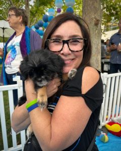 Happy woman cuddling a puppy