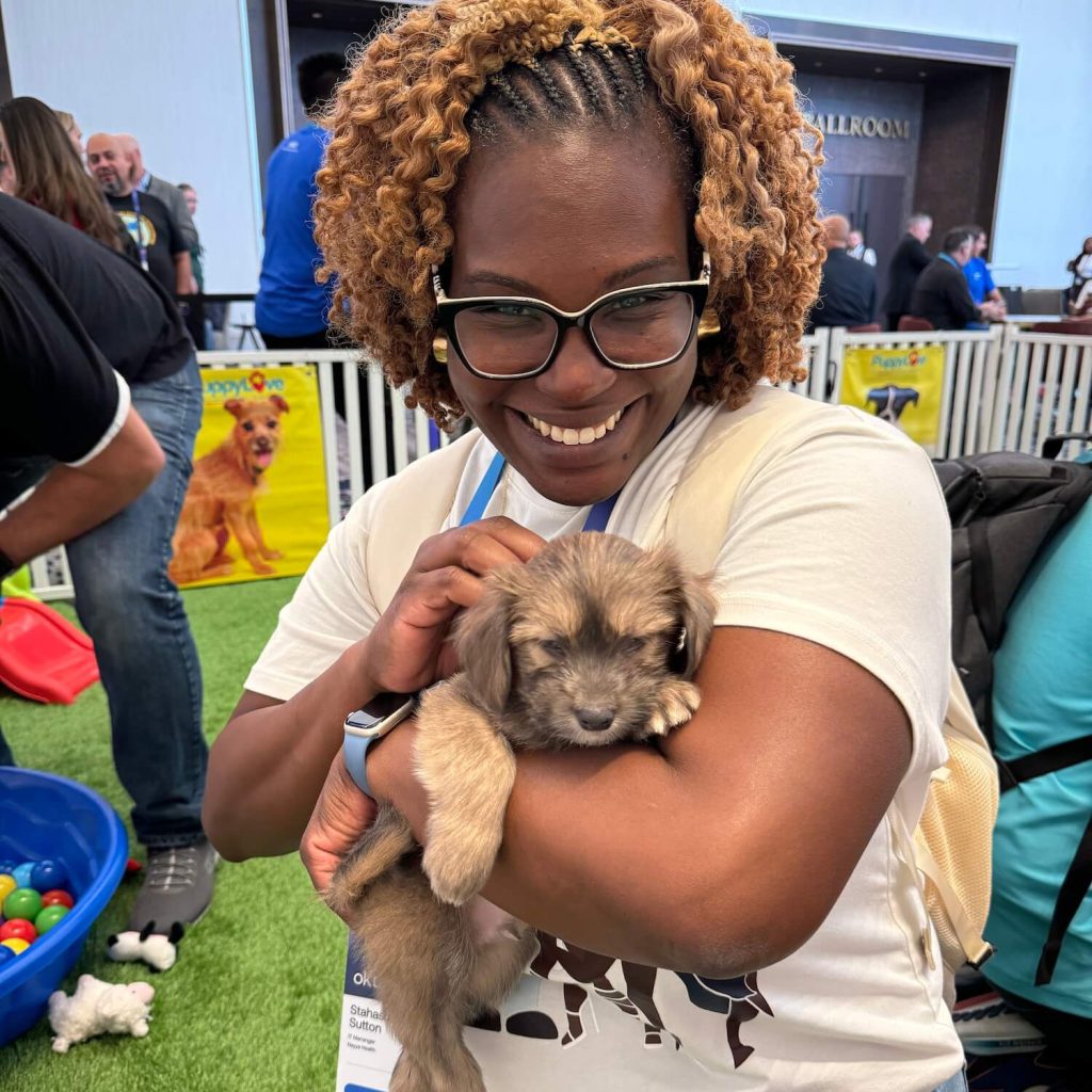 How to rent puppies for corporate wellness employee at a corporate wellness event snuggling a puppy