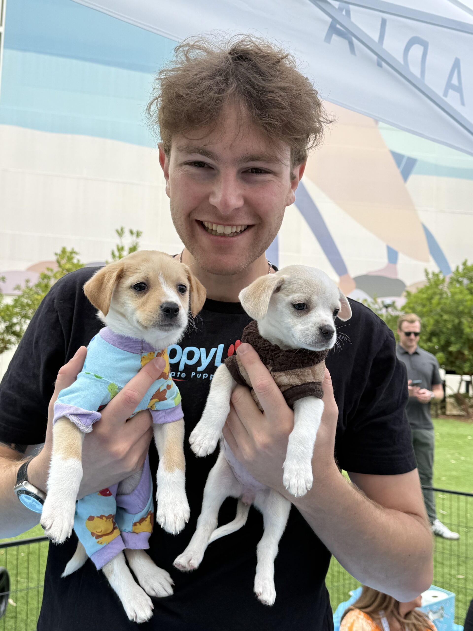 A man in a white shirt with a golden puppy